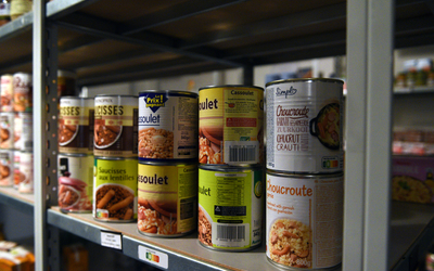 Des conserve sur les étagères du marché solidaire. 
