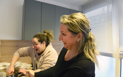 Deux bénéficiaires en pleine préparation d’un risotto au saumon, à l'Epicerie Solidaire. 