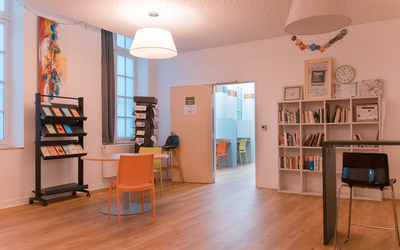 salle d'accueil avec chaises et bibliothèque