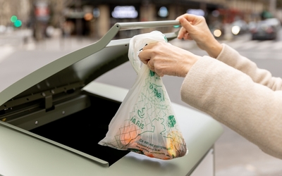 Personne mettant ses déchets alimentaires dans un point d'apport 