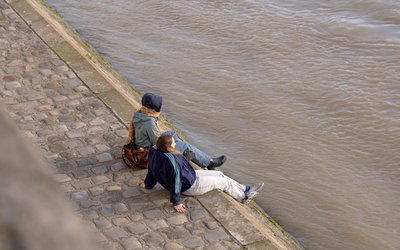 Deux personnes se reposent sur les quais de Seine. 