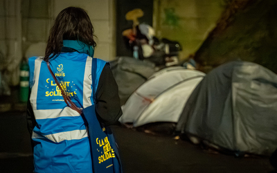 femme de dos avec un chasuble nuit de la solidarité