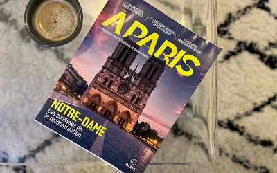 Le nouveau look du magazine A PARIS sur une table basse, près d'une tasse de café.