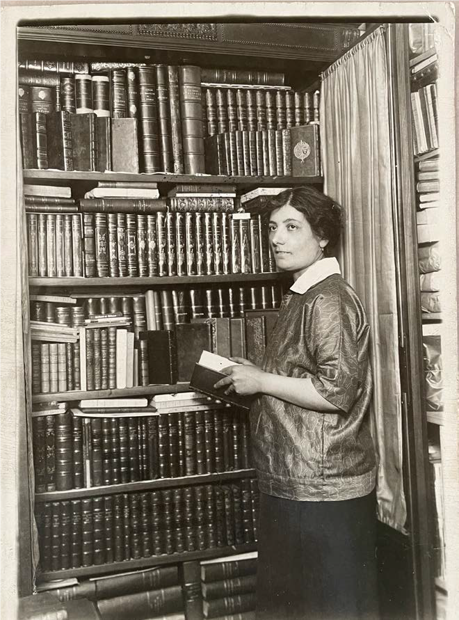 femme posant devant une bibliothèque