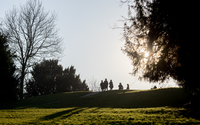 Des personnes se promènent sur les hauteurs du parc des Buttes Chaumont sous le soleil hivernal. 