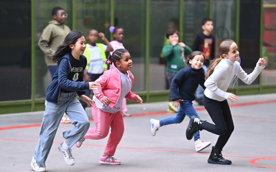 Des jeunes filles  du centre de loisirs à parité font la course dans la cour de l'école Buffet