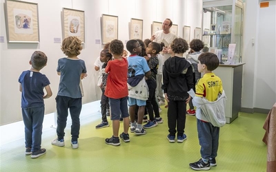 Des enfants en train d'observer des oeuvres dans une bibliothèque