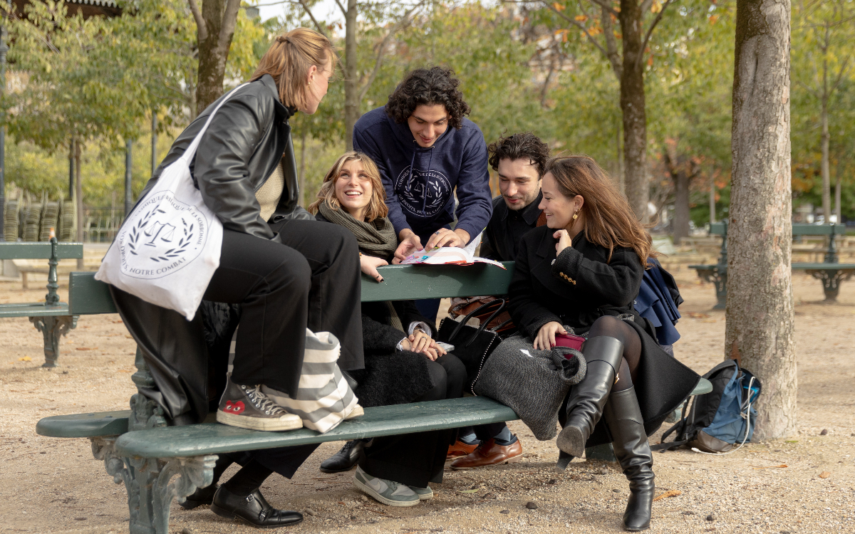 Jeunes adultes discutant sur un banc du parc du Luxembourg. 