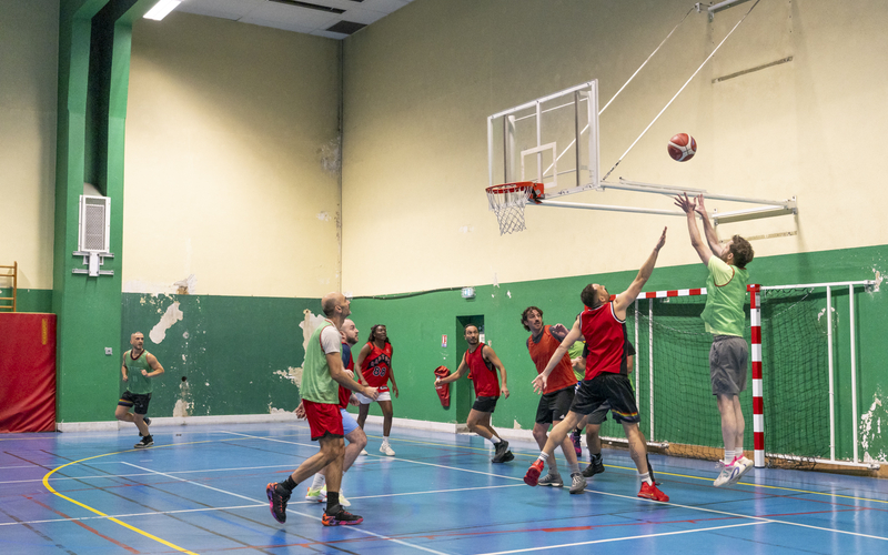 Personnes jouant au basketball dans un gymnase. 