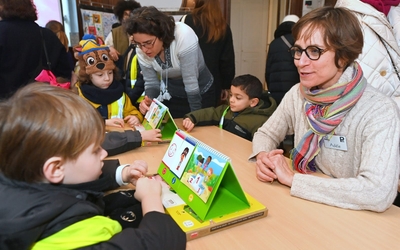 Un enfant de maternelle joue au jeu de cartes des émotions avec une adulte