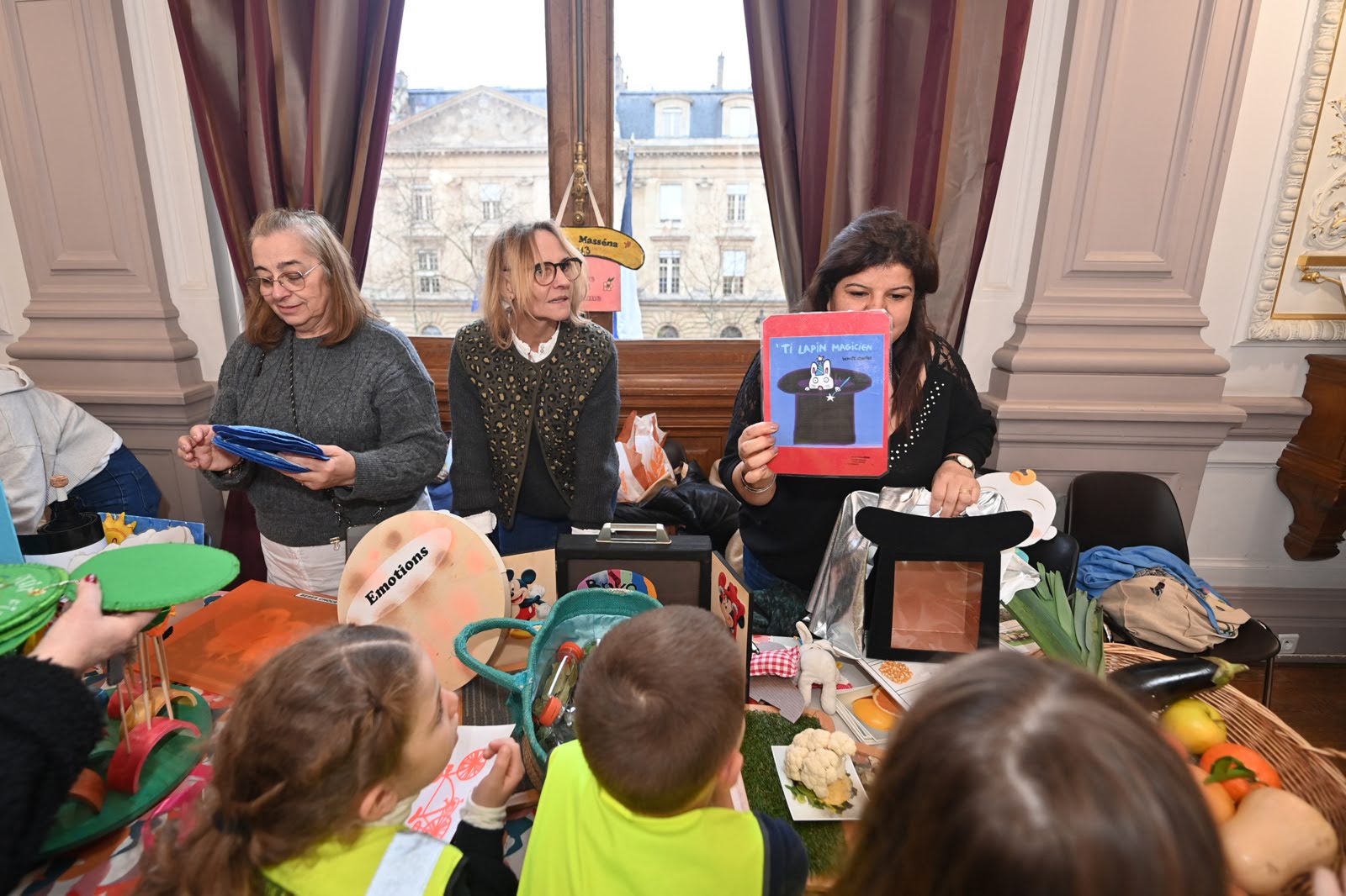 Des adultes montrent des images colorées autour des émotions à de jeunes enfants