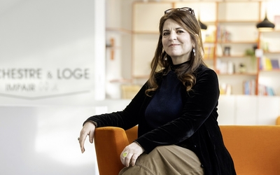 Agnès Jaoui assise sur un fauteuil dans le hall du théâtre de la Concorde