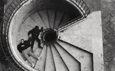 Photo en Noir et Blanc argentique de deux hommes allongés dans des escaliers à spirale