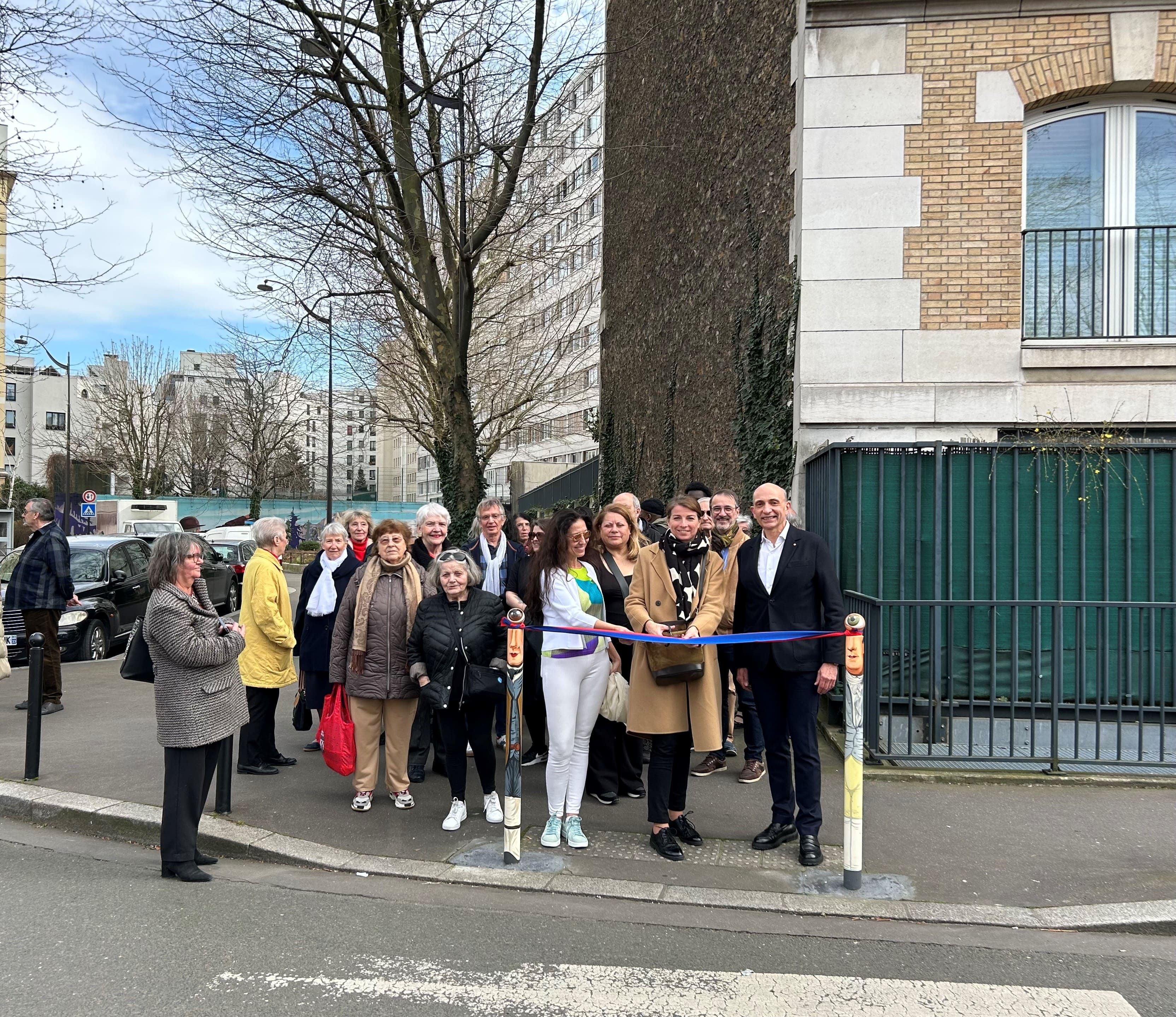 Photo du conseil de quartier et des élus en train de couper le ruban d'ianuguration situé entre deux potelets