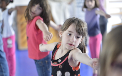 Des jeunes filles tendent les bras en dansant 