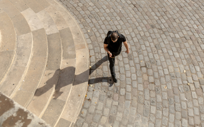 Un promeneur foulant le sol pavé du quartier Saint-Blaise.