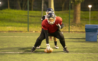 Deux joueurs de football américain en position d'attaque.