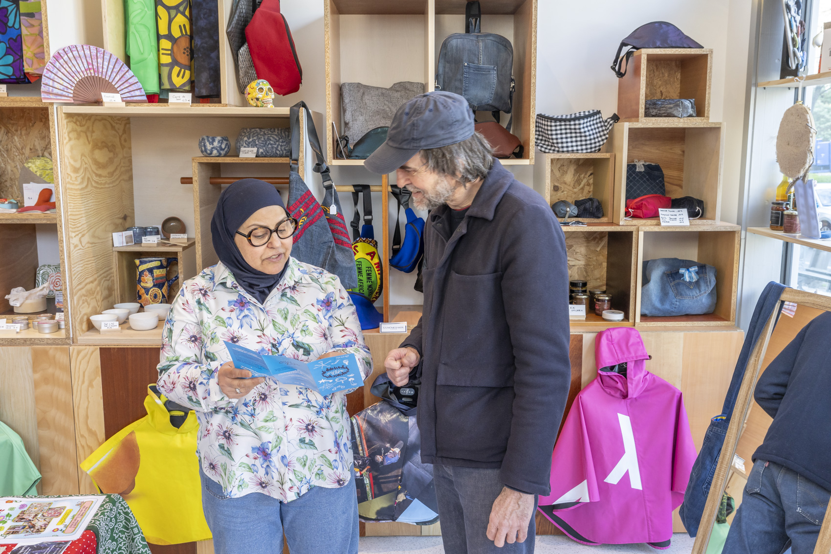 Une femme portant un foulard montre un document à un homme portant une casquette