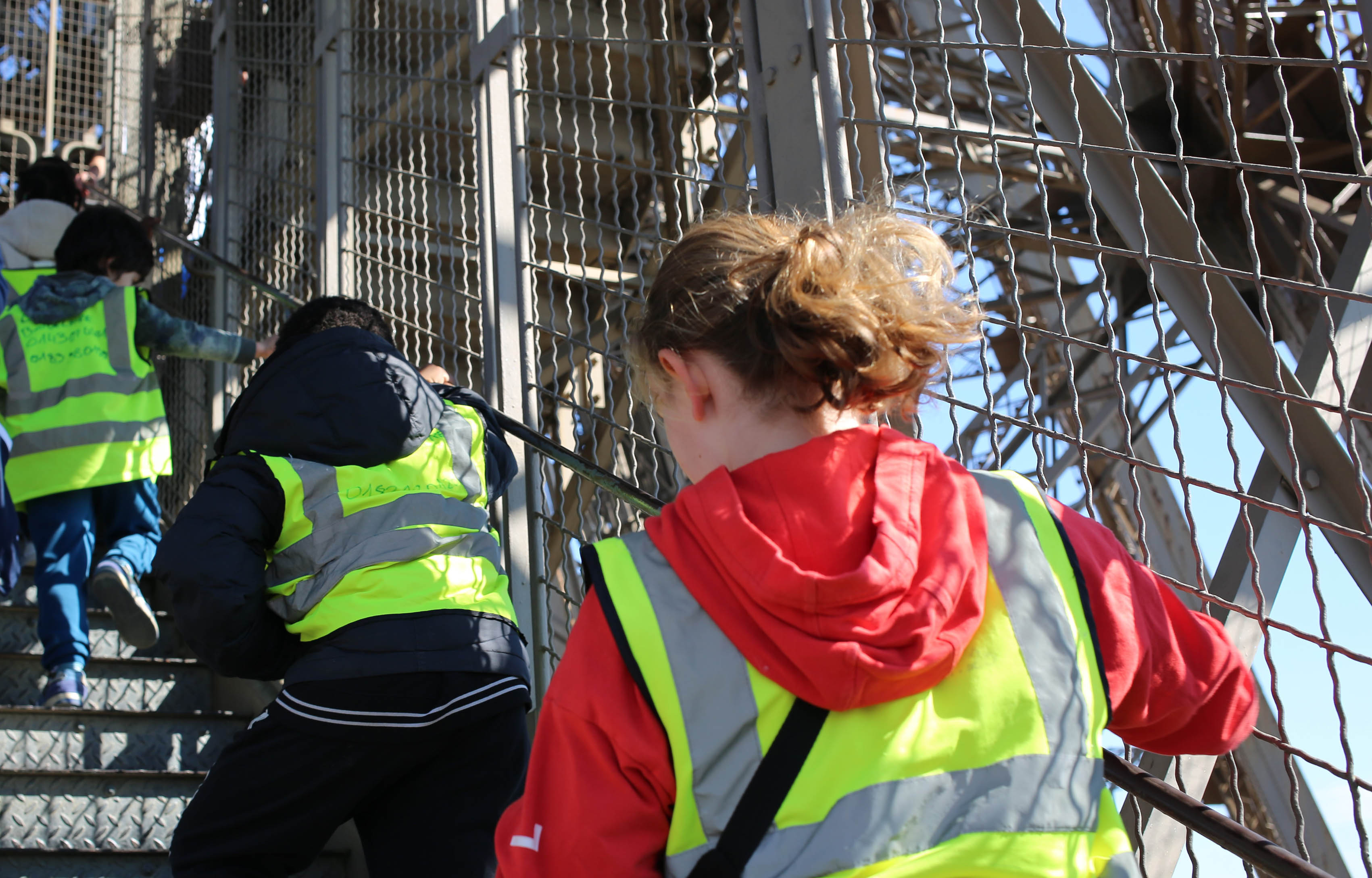 Des jeunes enfants grimpent les escaliers de la tour Eiffel