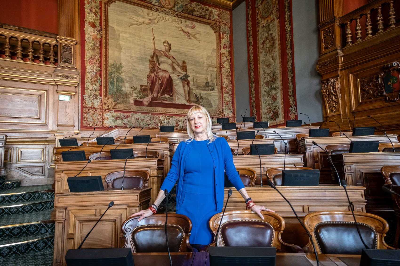 Une femme blonde debout dans la salle du Conseil de Paris.