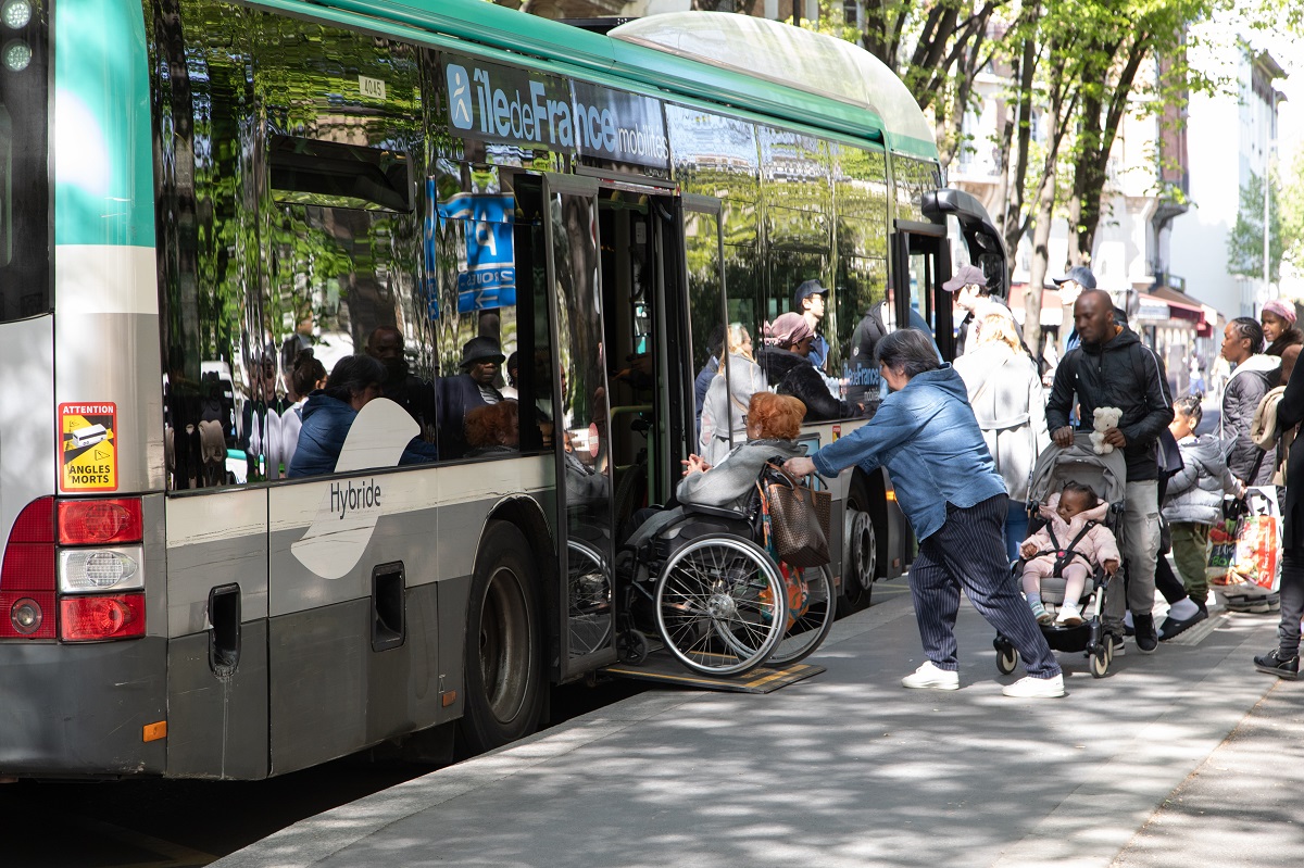 Photo de la montée dans un bus d'une personne à mobilité réduite avec la rampe d'accès