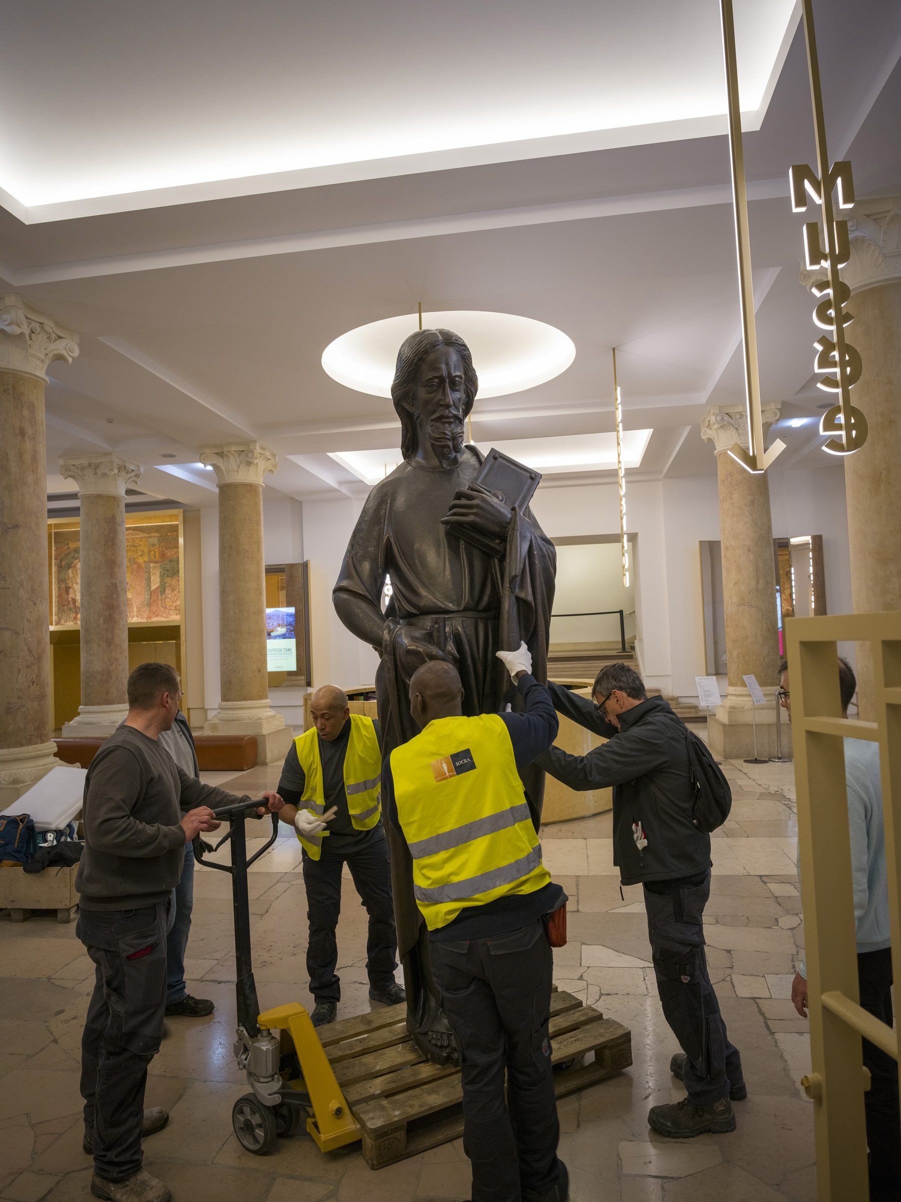 des ouvriers  déplacent les statues