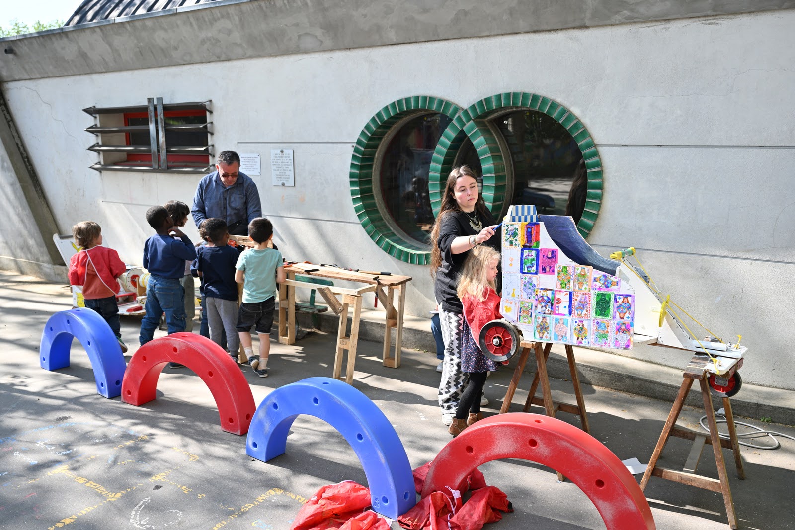 deux groupes d'enfants de maternelle travaillent sur leur pushcar, un groupe au bricolage et un groupe à la décoration