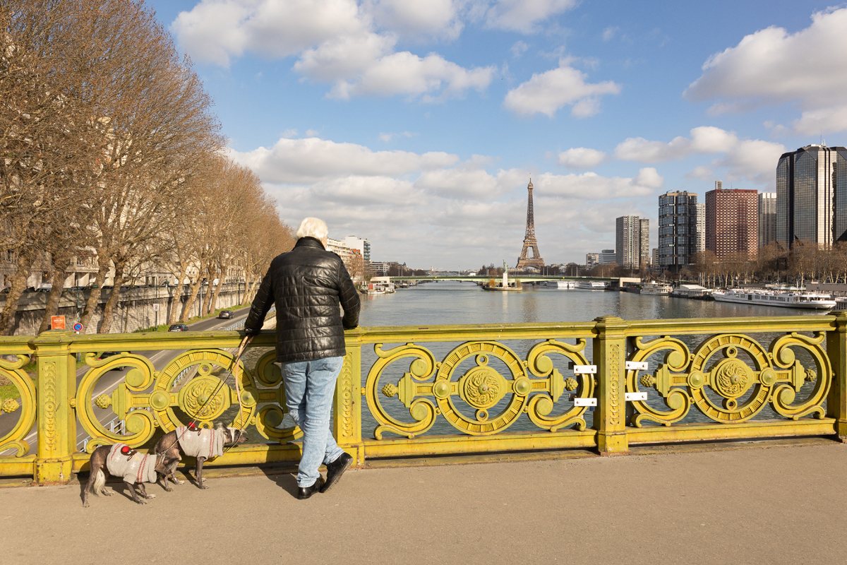Un homme observe la Tour Eiffel depuis le pont Mirabeau. 