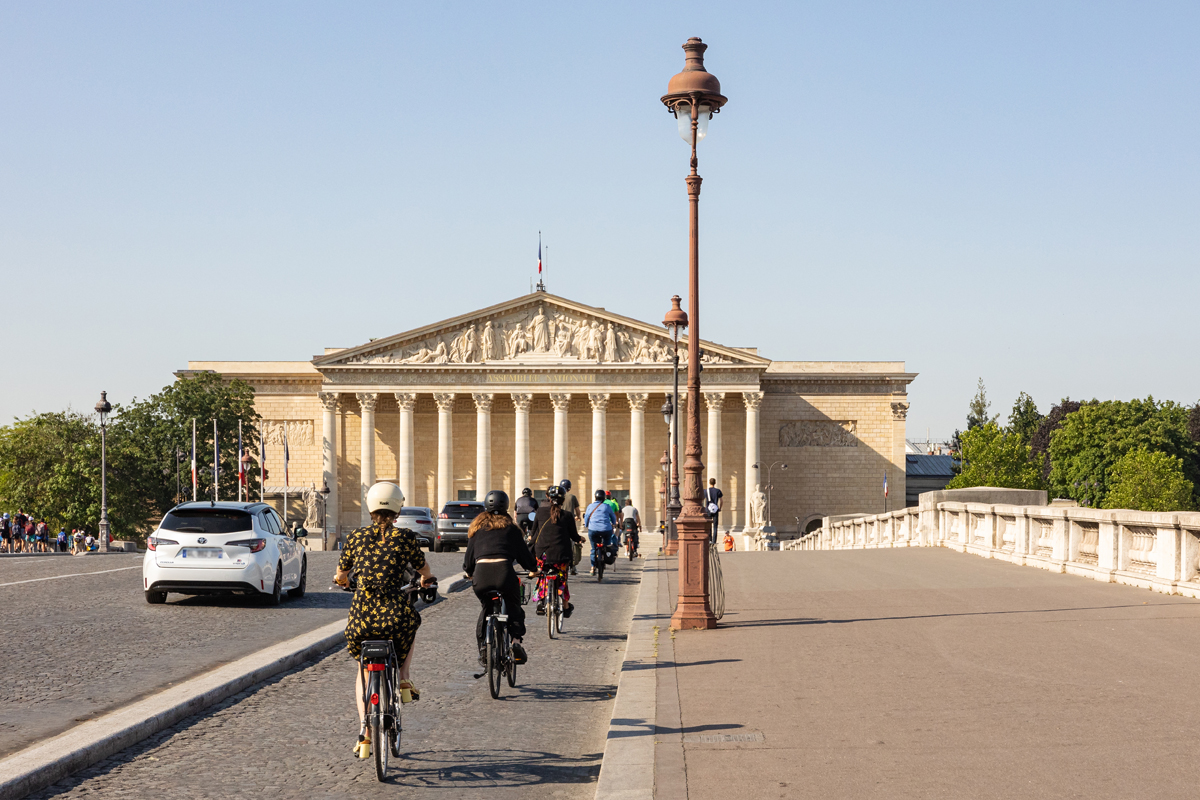 Des cyclistes devant l'Assemblée Nationale depuis le pont de la Concorde. 