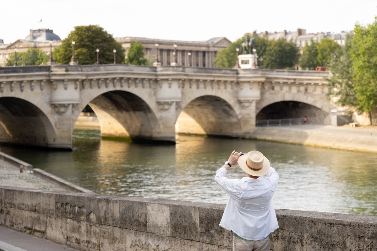 Une touriste prenant une photo du pont neuf.