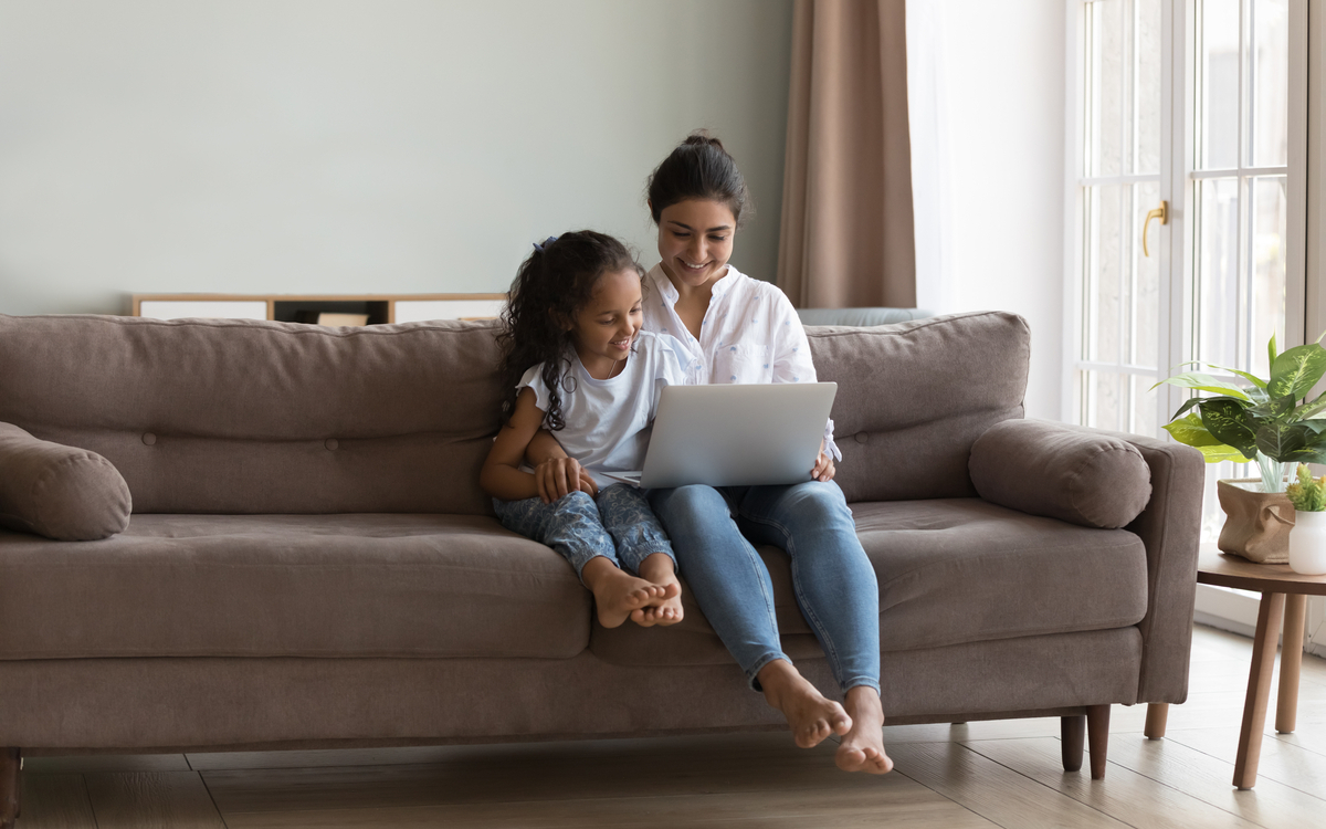enfant qui regarde un ordinateur avec sa mere