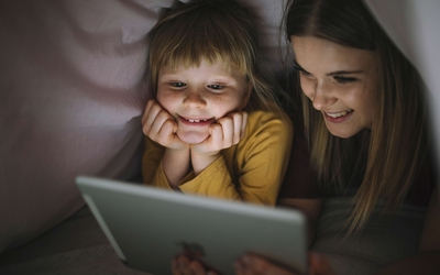 Une petite fille et une plus grande qui regardent un écran