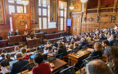 Des gens assis dans la salle du Conseil