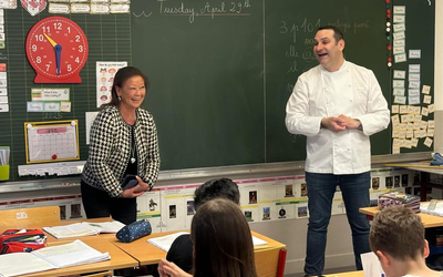 Jeanne d'hauteserre, maire du 8e arrondissement de Paris, se tient à gauche d'un tableau noir. A sa droite, le chef Thomas Boullaut devant la classe