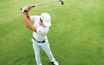 Un golfeur en train de réaliser un swing sur le green