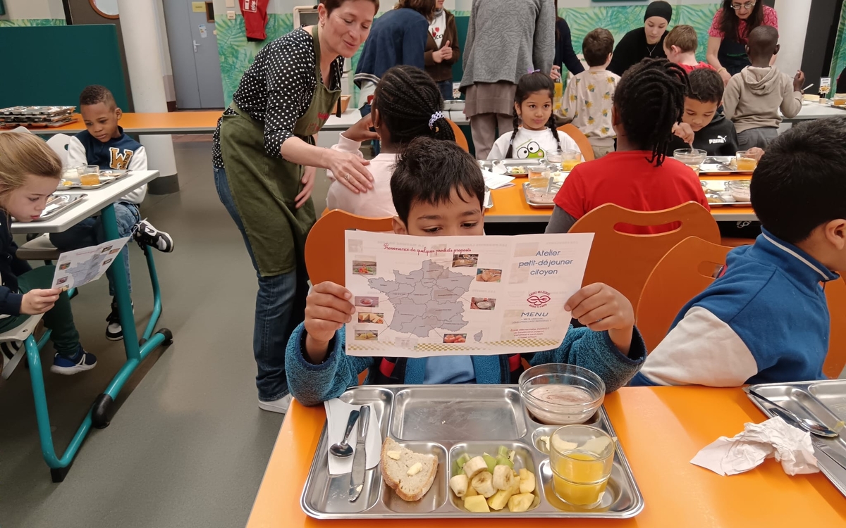 un enfant à la cantine lisant le menu de son petit déjeuner