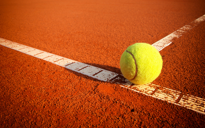 Une balle jaune sur un court en terre battue