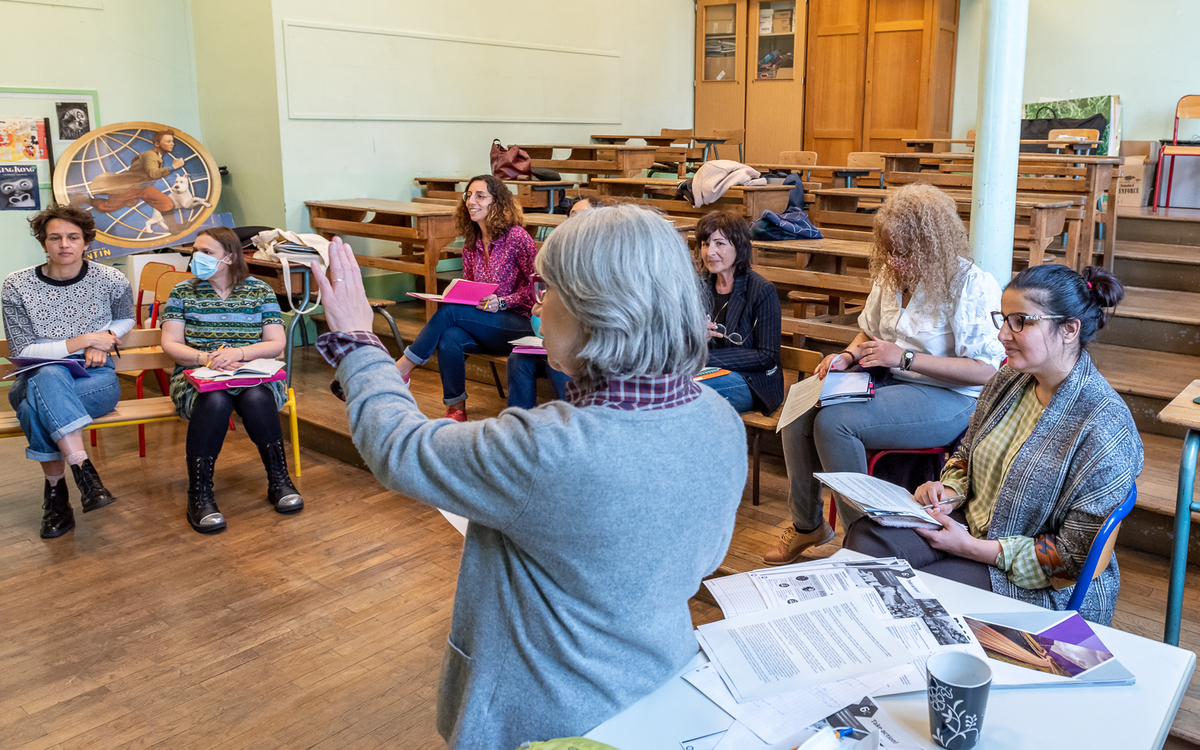 Une professeure d'anglais enseigne à des adultes débutants