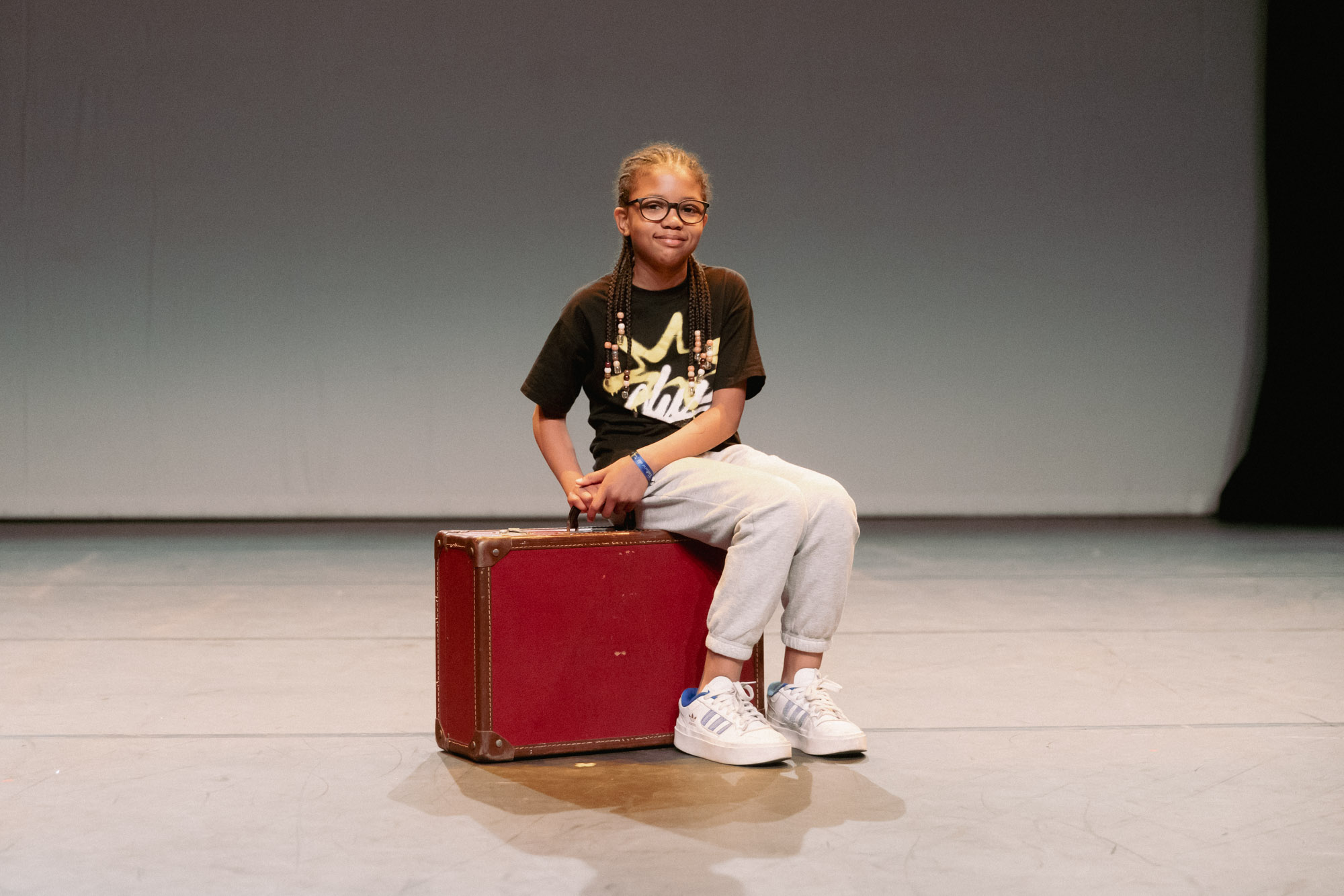 Une petite fille assise sur une valise