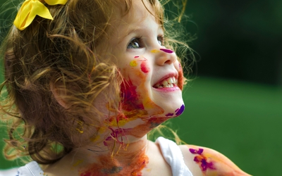 petite fille souriante avec taches de peinture