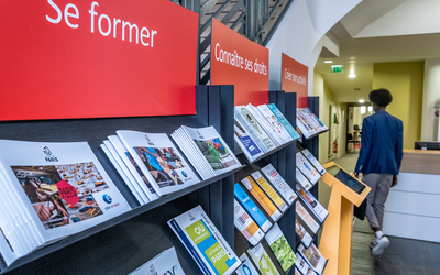 Prospectus au sujet de l'emploi et la formation disposés sur un présentoir dans un centre dédié à l'emploi formation