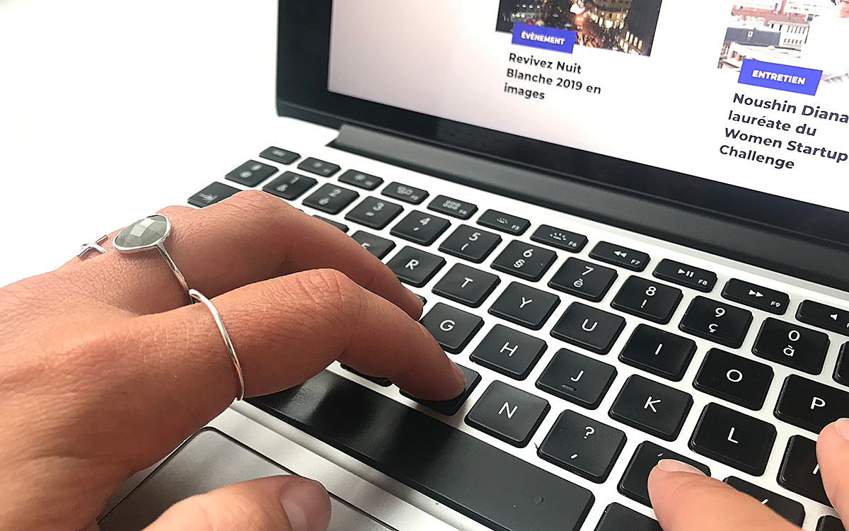 Une personne pianote sur son ordinateur en étant sur le site de la ville de Paris