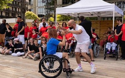 Deux personnes danse ensemble : une personne valide et une personne en fauteuil 