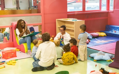 Agents de la ville jouant avec des enfants dans une crèche