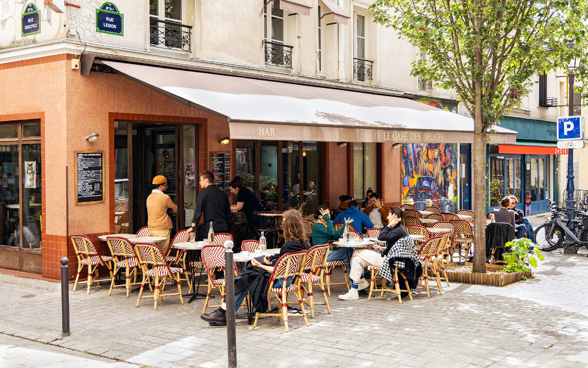 Personnes en terrasse du café des délices, lors du Refugee Food Festival.
