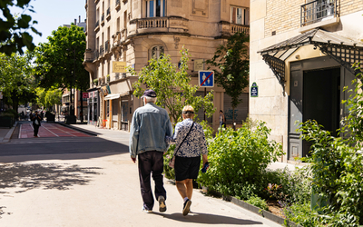 Couple de seniors marchant dans une rue piétonne. 