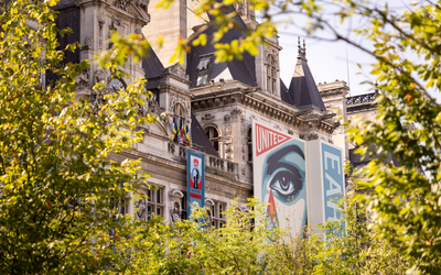 Façade de l'Hôtel de Ville avec l'affiche de l'artiste OBEY depuis la foret urbaine du parvis de l'Hôtel de Ville. 