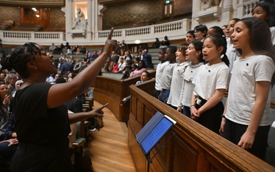 Des enfants chantent dans le grand amphithéâtre de la Sorbonne