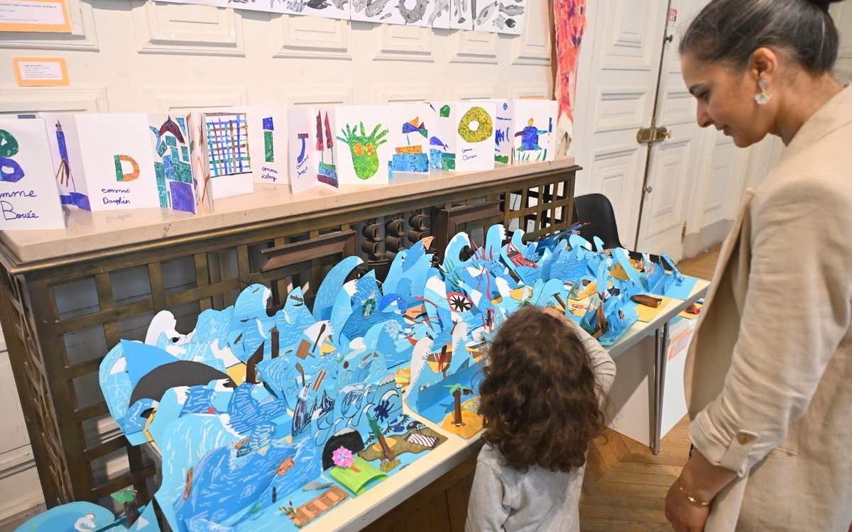 Une maman et son enfant observent une création graphique autour des vagues