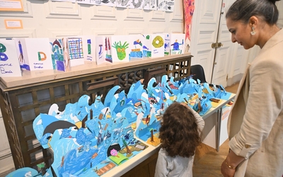 Une maman et son enfant observent une création graphique autour des vagues